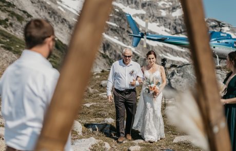 The bride walks down to the groom on a wedding at the mountain from helicopter ride